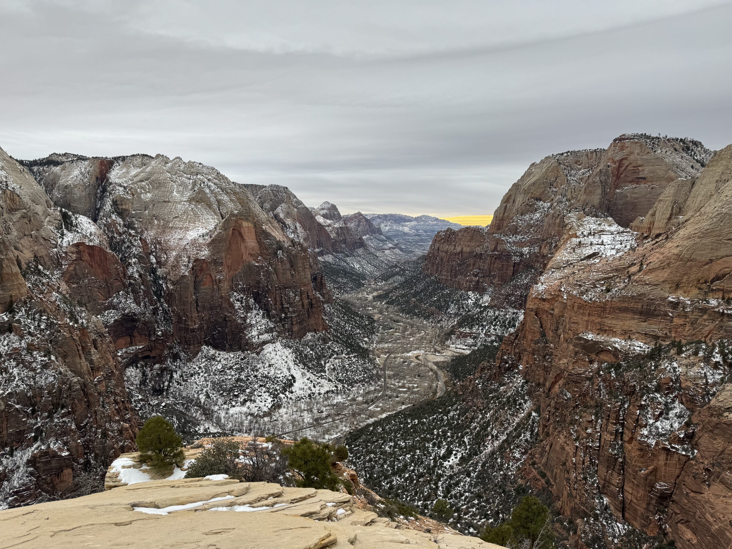Winter view of Zion National Park with snow-dusted red rock cliffs and a winding valley below