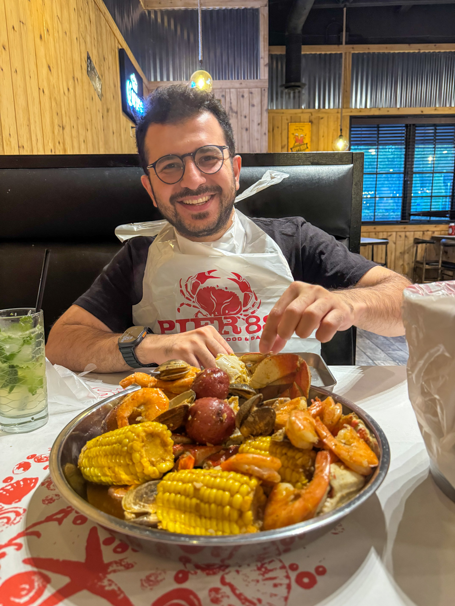 Me enjoying a seafood boil with shrimp, corn, potatoes, and clams at a restaurant in Seattle.
