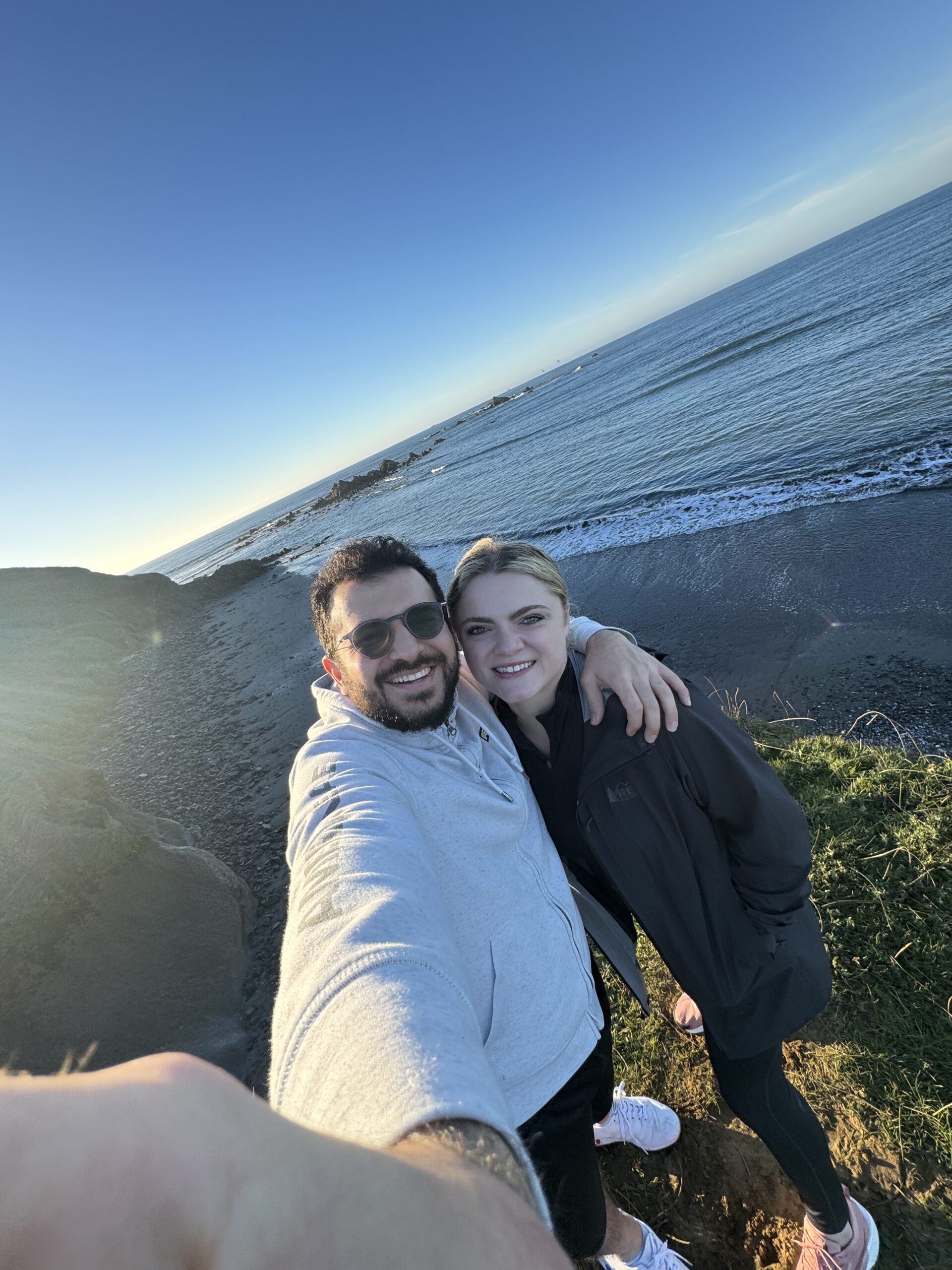 Couple taking a selfie overlooking the Pacific Ocean at sunset on the Washington coast.
