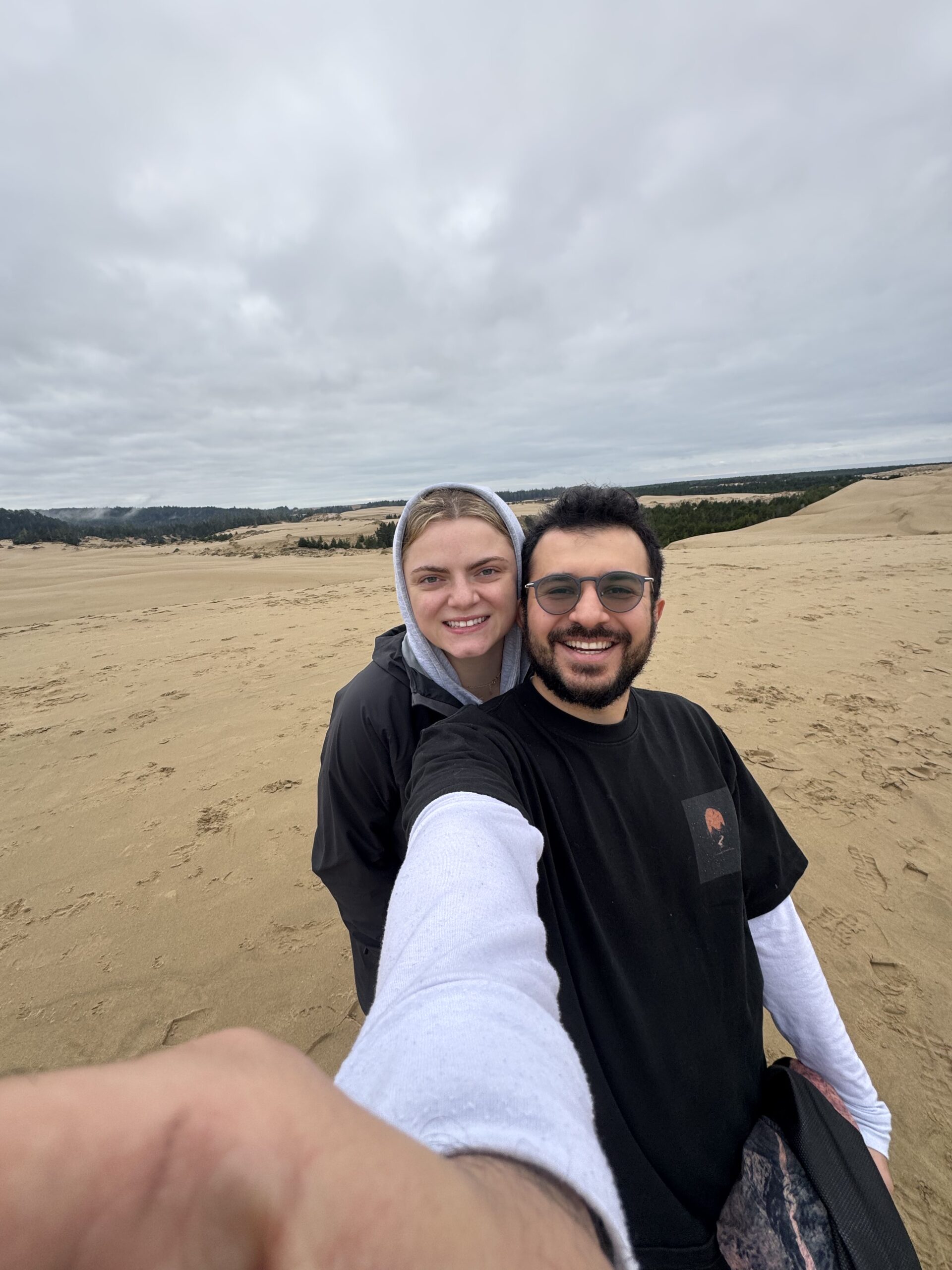 Couple taking a selfie on large sand dunes in Washington State.