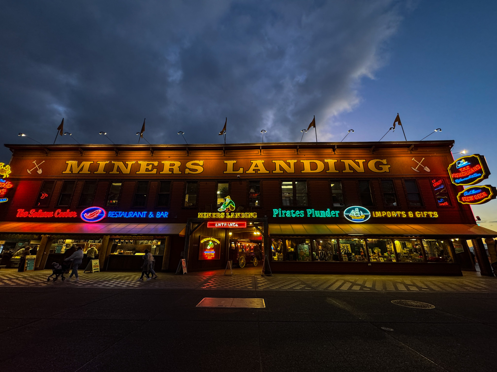 Miners Landing building illuminated at night on Seattle’s waterfront at Pier 57.
