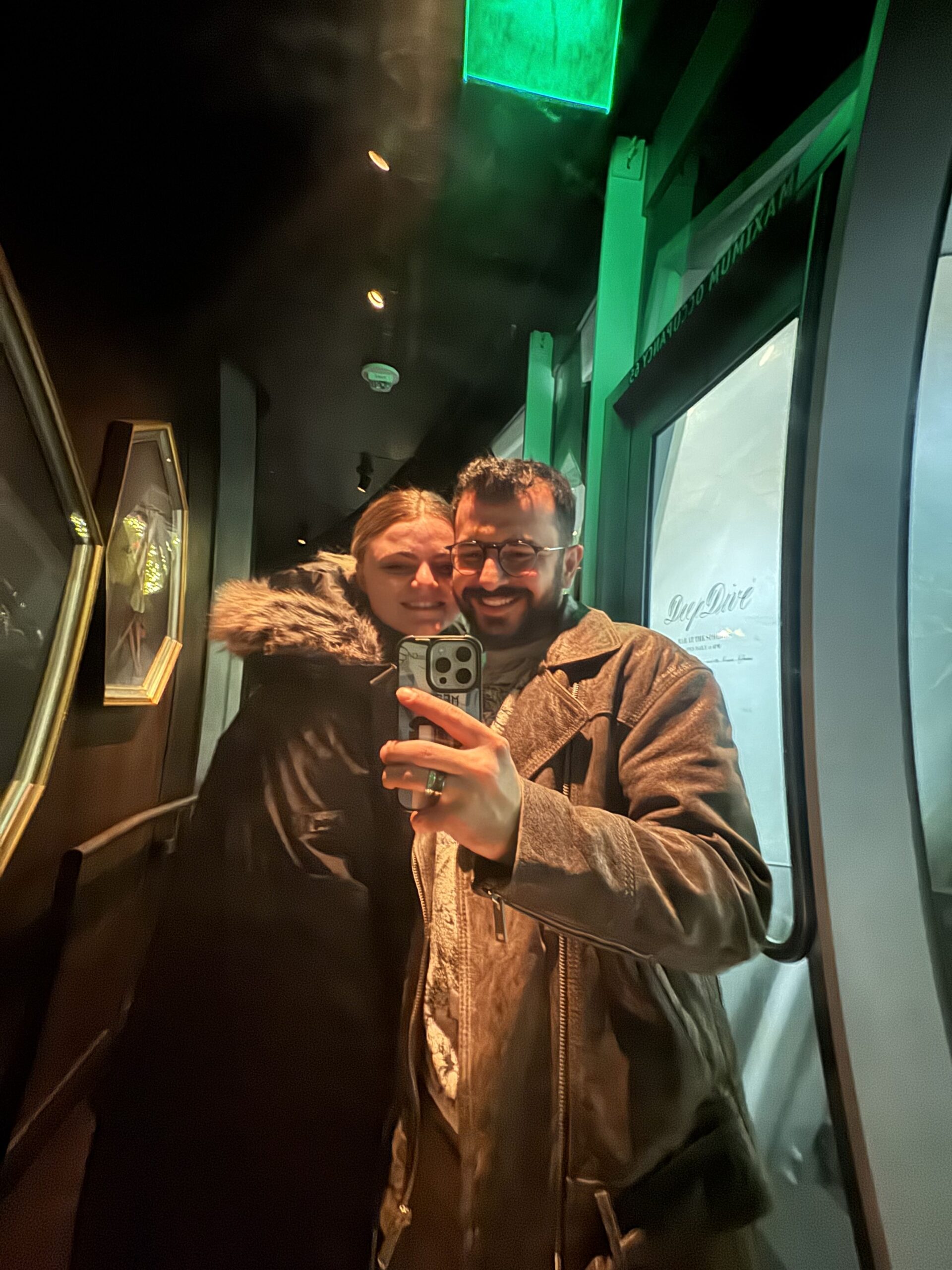 Couple taking a mirror selfie indoors during their travels.