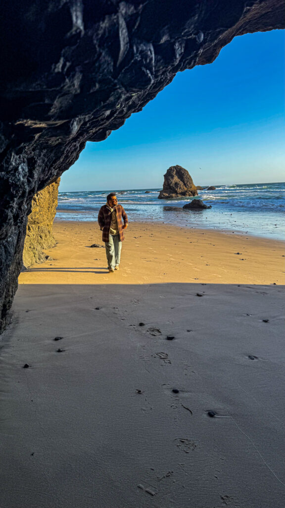 View from inside a cave at Tunnel Beach on the Oregon Coast looking out toward the ocean and sea stacks.