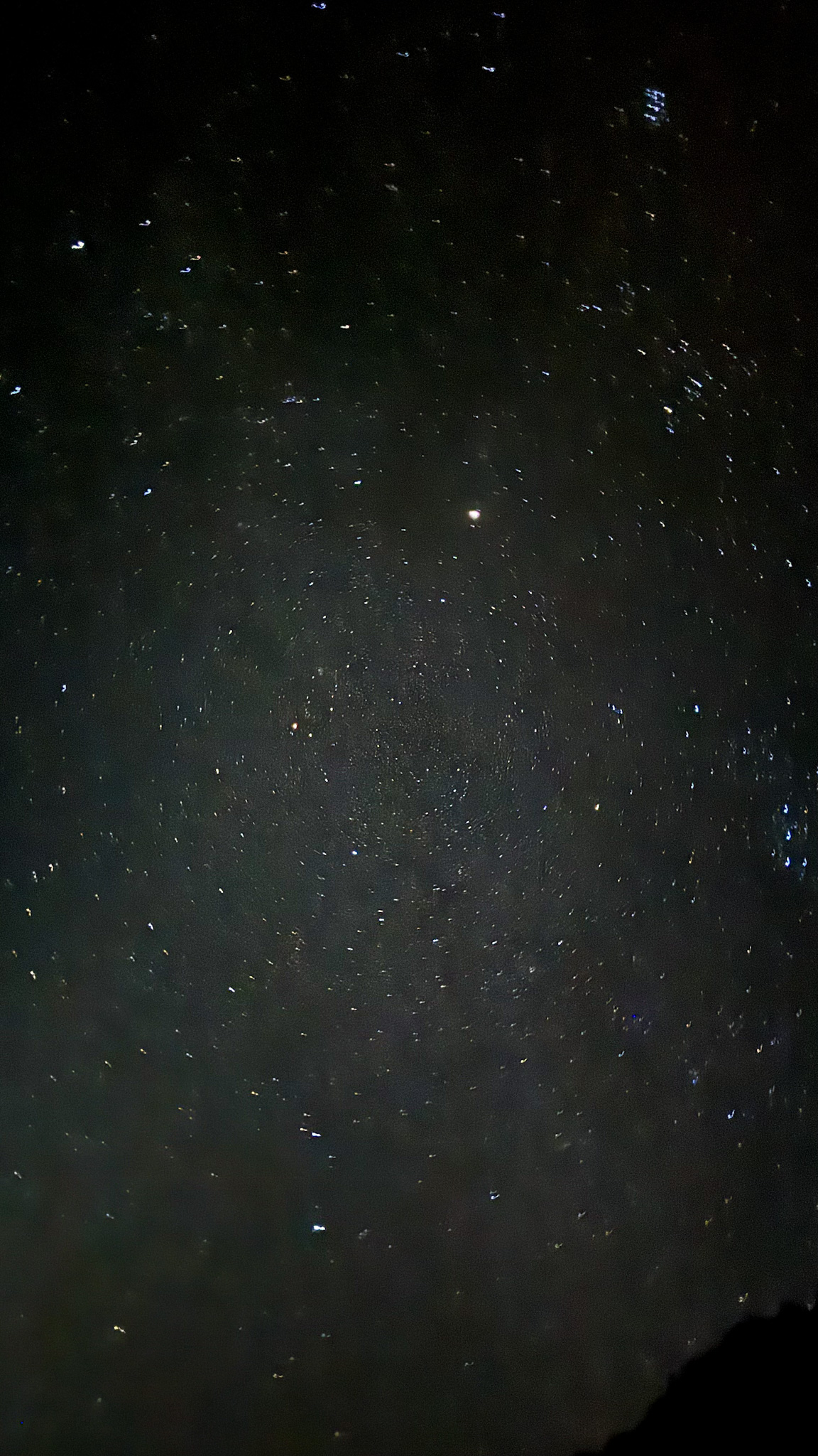 Star-filled night sky over Yosemite with visible Milky Way and long exposure light patterns.