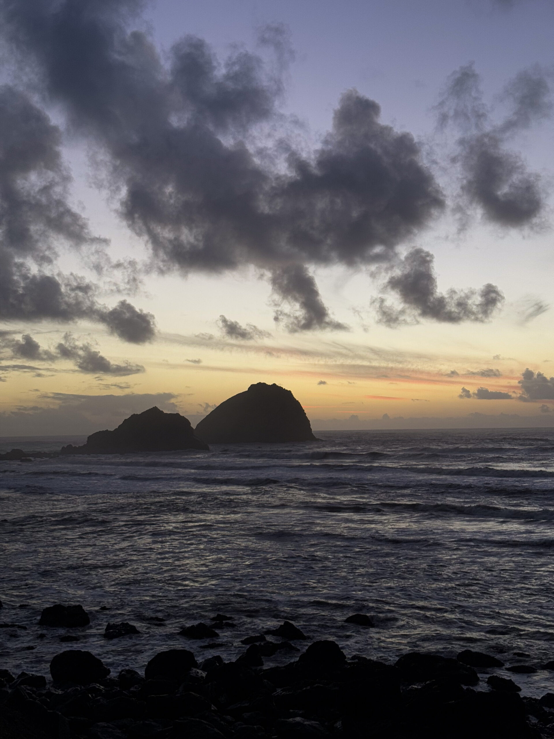 Sea stacks rising from the Pacific Ocean at sunset on the Oregon Coast along Highway 101.
