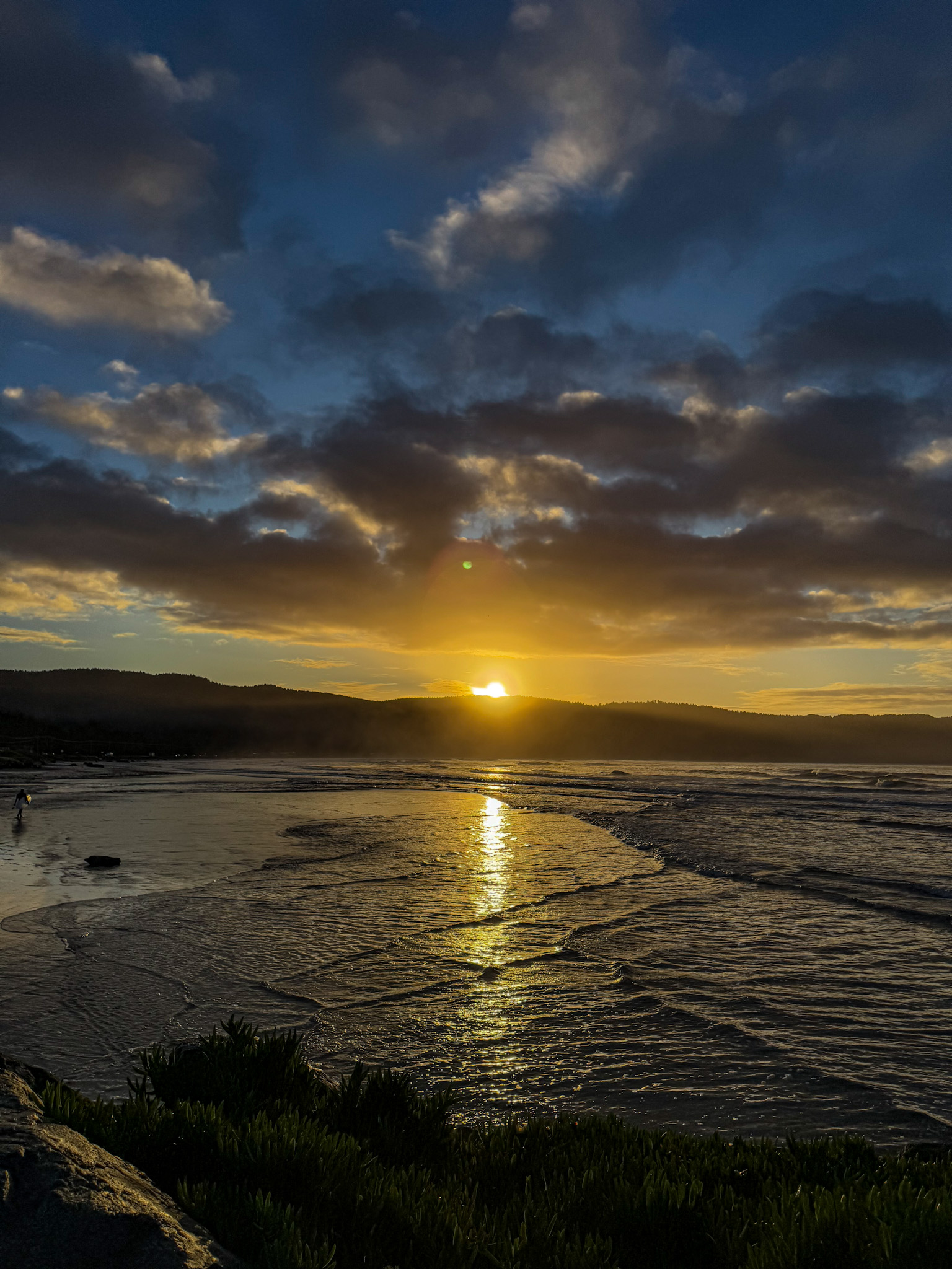 Golden sunset over the Pacific Ocean along the Oregon Coast with waves and dramatic clouds.
