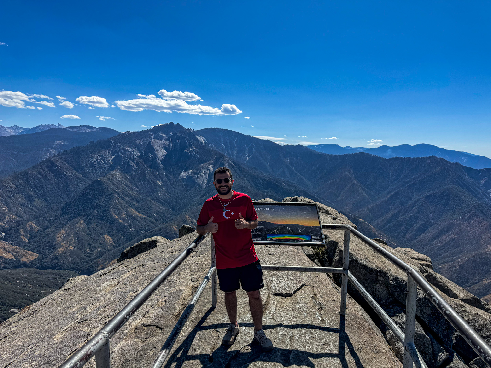 Traveler standing at Moro Rock viewpoint overlooking mountains in Sequoia National Park California.