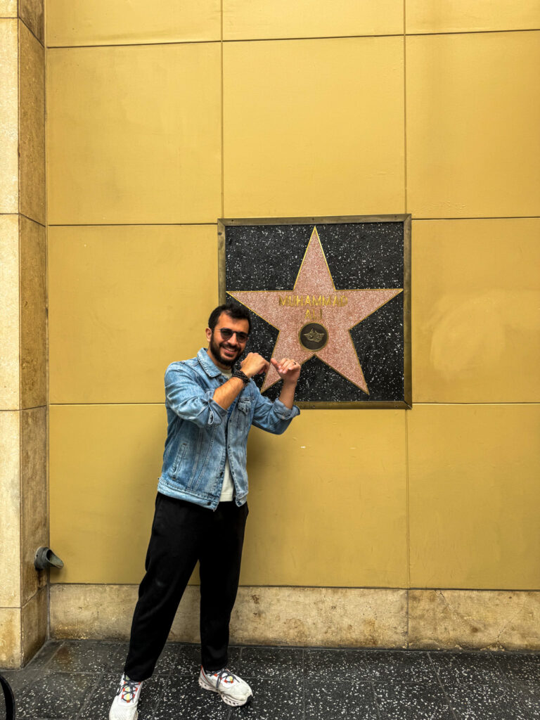 Traveler posing next to Muhammad Ali’s star on the Hollywood Walk of Fame in Los Angeles.