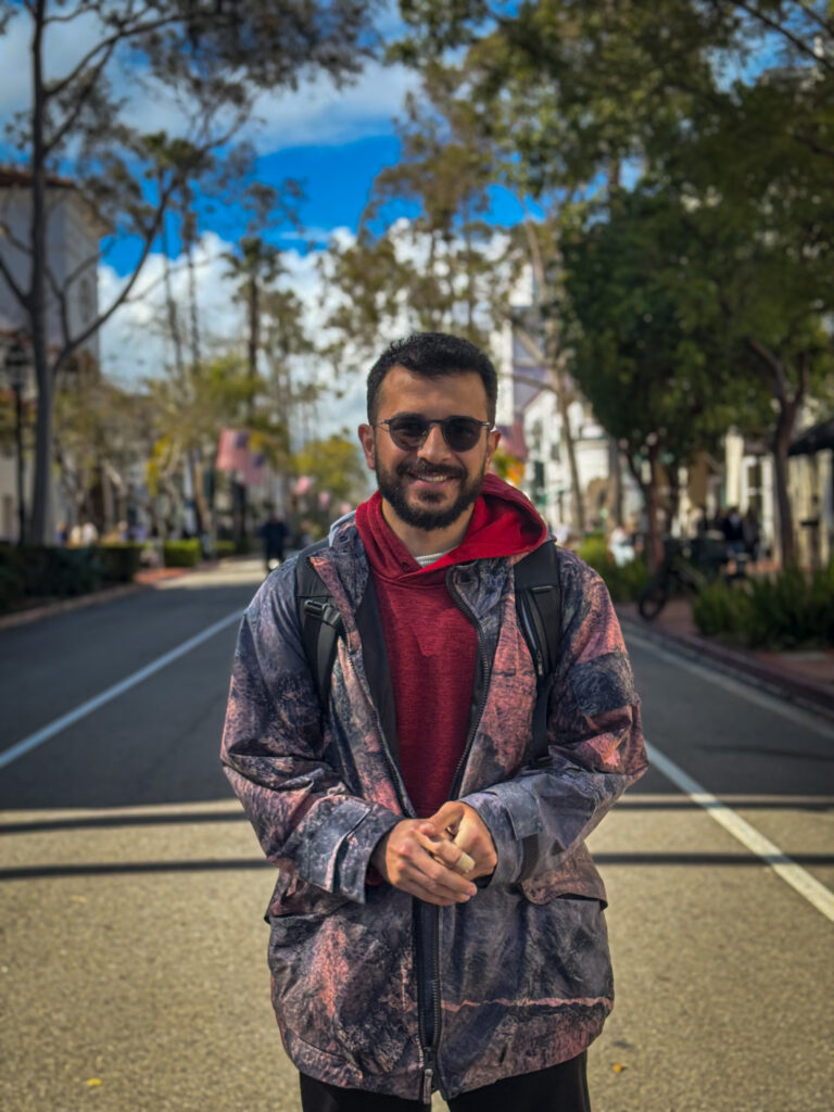 Traveler standing in the middle of a palm tree-lined street in Santa Barbara, California.