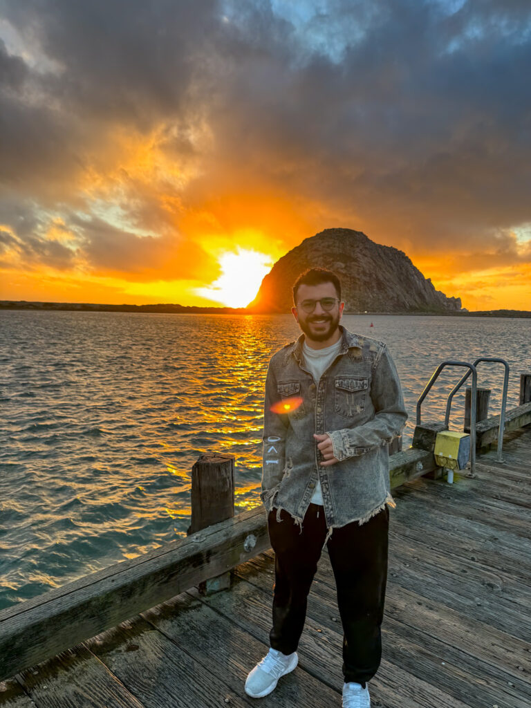 Traveler standing near the water during sunset at Morro Bay, California.