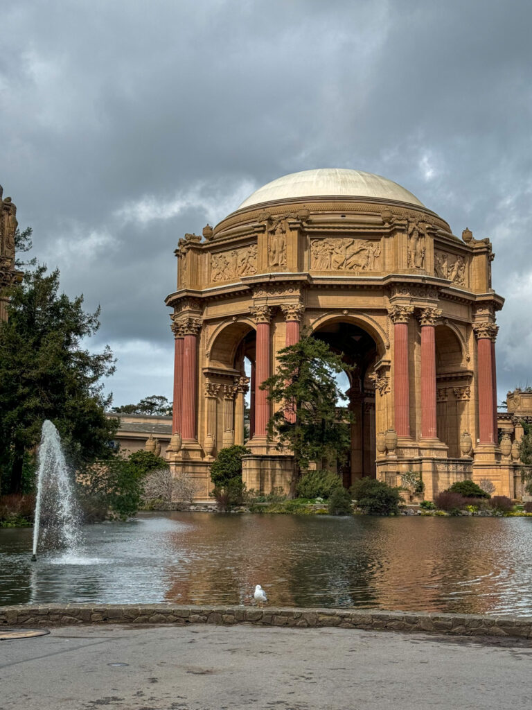 Palace of Fine Arts in San Francisco with reflecting pond and dramatic cloudy sky.