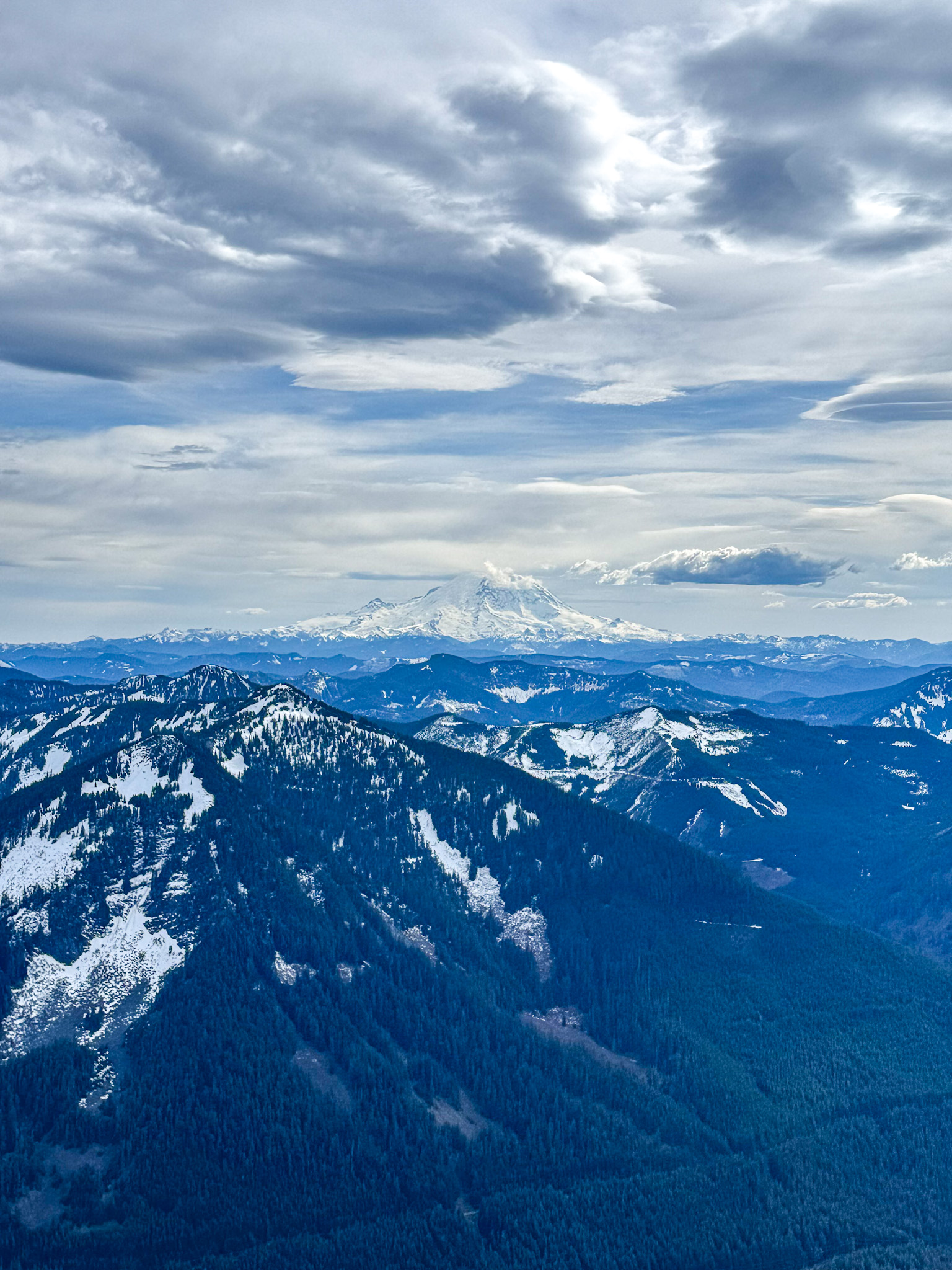 Panoramic view of Mount Rainier and snow-covered Cascade mountains from Granite Mountain summit in Washington.