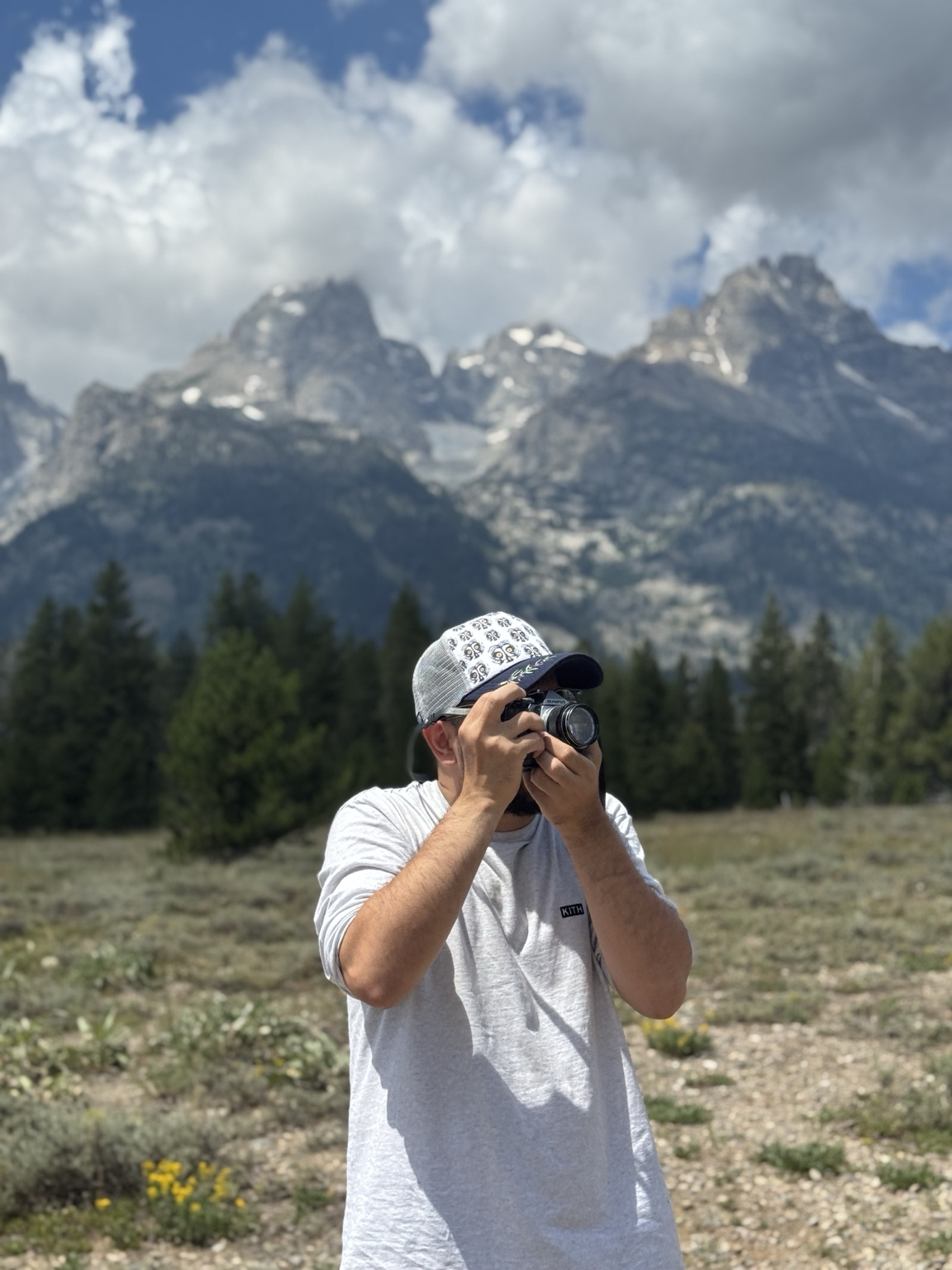 Photographer taking photos with the Grand Teton Range in the background at Grand Teton National Park, Wyoming.