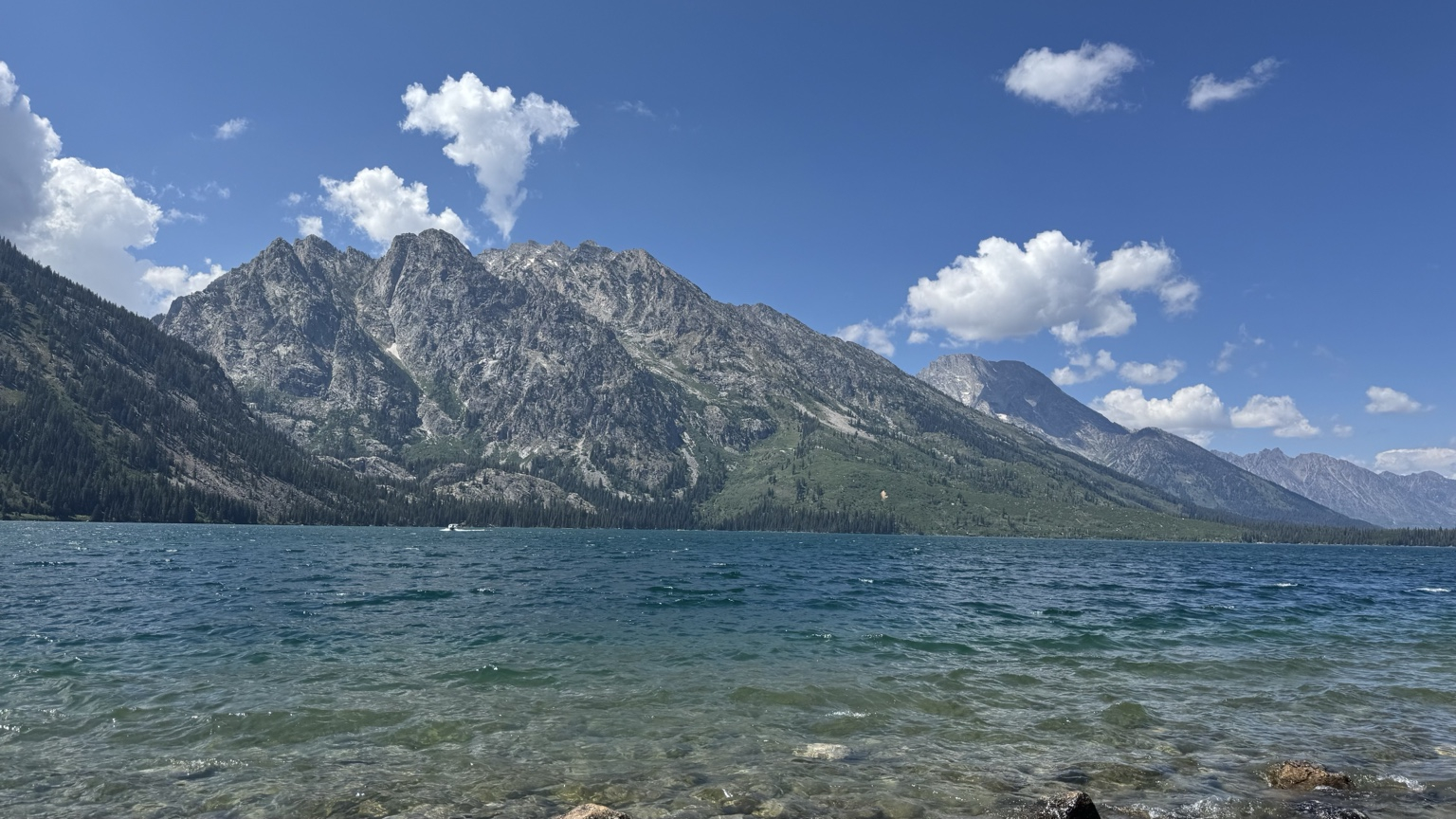 Jenny Lake with crystal-clear water and the Teton Range on a sunny day in Grand Teton National Park, Wyoming.