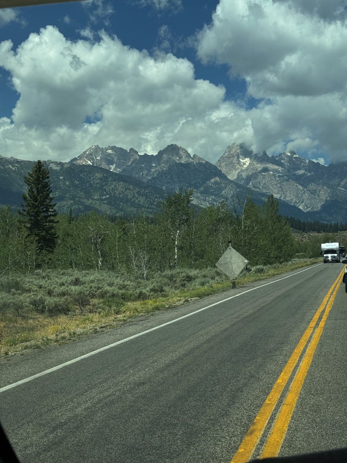 Scenic drive through Grand Teton National Park with the Teton Range towering over the highway in Wyoming.