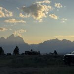 Sunset over Grand Teton National Park viewed from an RV campground with the Teton Range silhouetted against the evening sky.